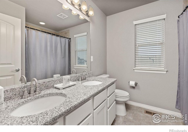 bathroom with vanity, toilet, and tile patterned floors