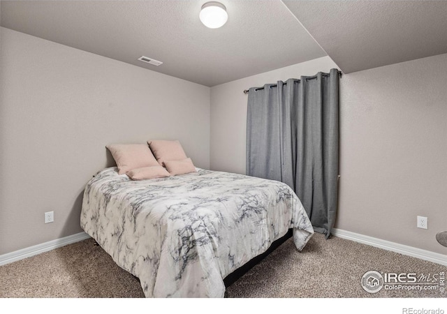 carpeted bedroom featuring a textured ceiling