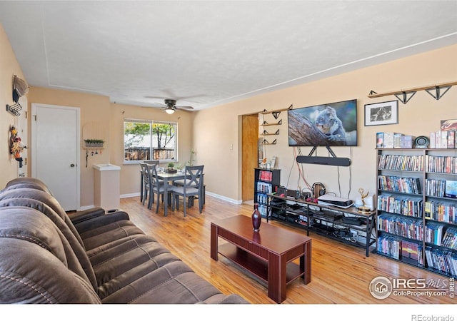 living room featuring hardwood / wood-style flooring and ceiling fan