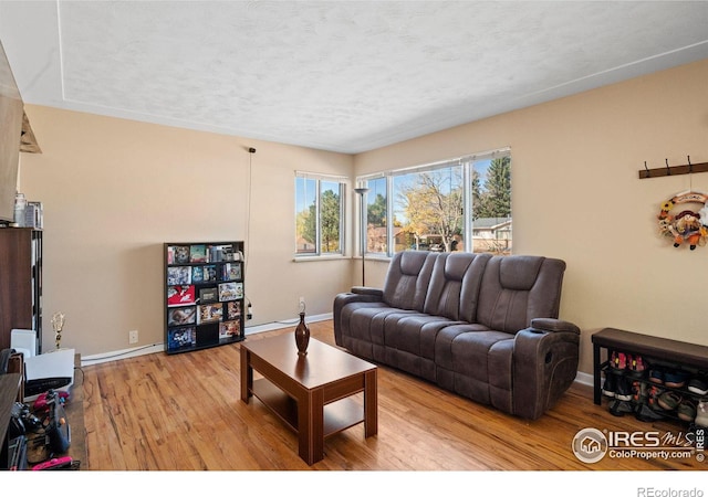 living room featuring light hardwood / wood-style flooring and a textured ceiling