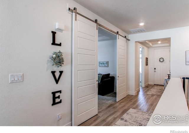 hall featuring a barn door and light wood-type flooring