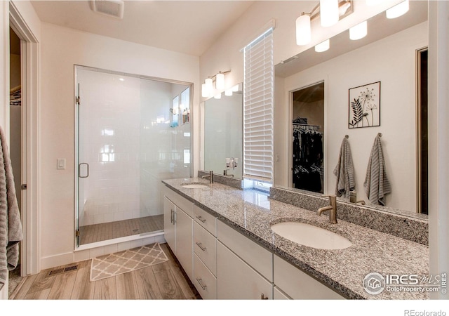 bathroom with vanity, an enclosed shower, and hardwood / wood-style flooring