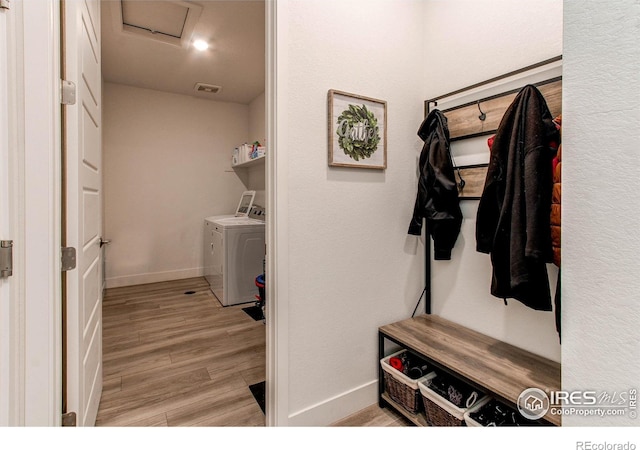 washroom with light hardwood / wood-style floors and washing machine and clothes dryer