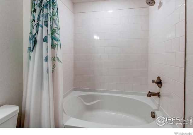 bathroom featuring toilet and shower / bath combination with curtain