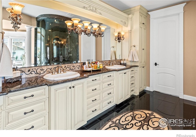 bathroom featuring vanity, decorative columns, a notable chandelier, and tile patterned flooring