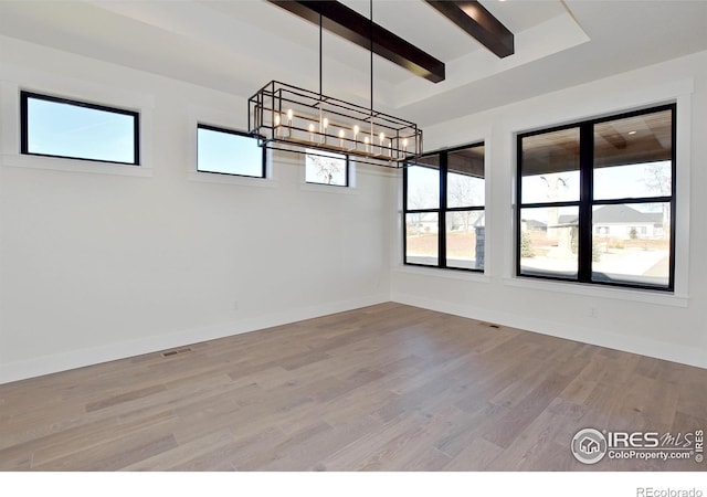 unfurnished room with beamed ceiling, a chandelier, and light hardwood / wood-style flooring