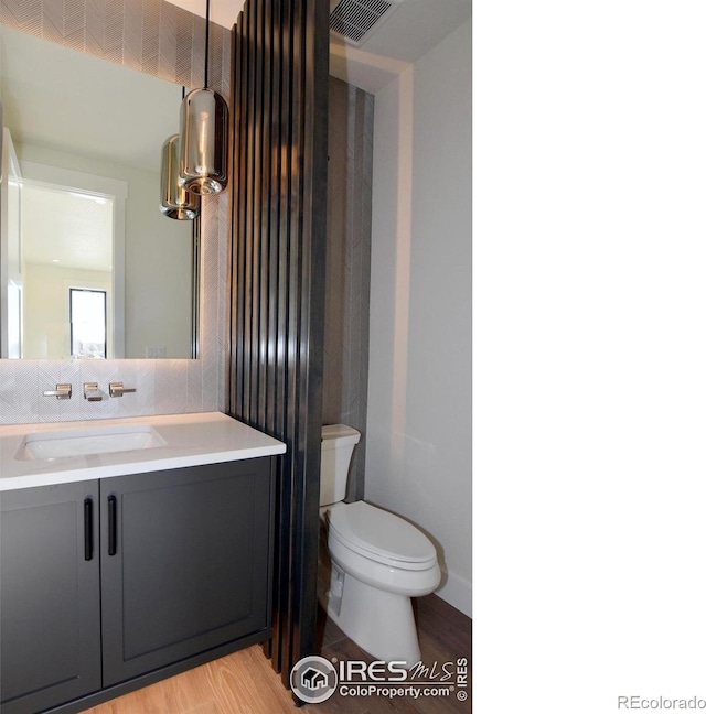 bathroom featuring hardwood / wood-style floors, vanity, and toilet