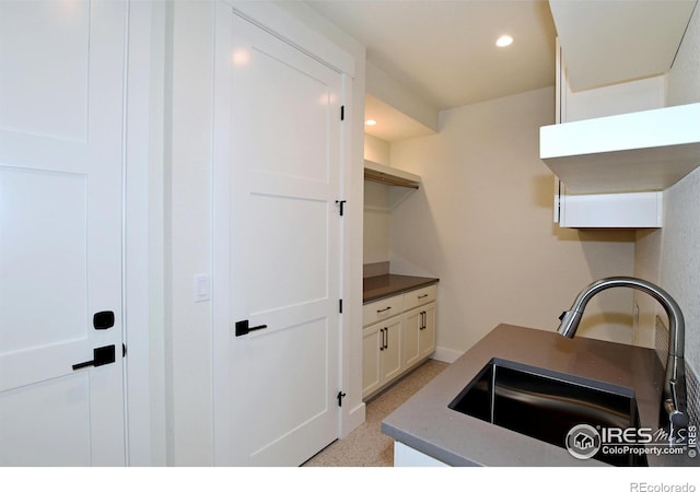 kitchen featuring white cabinetry and sink