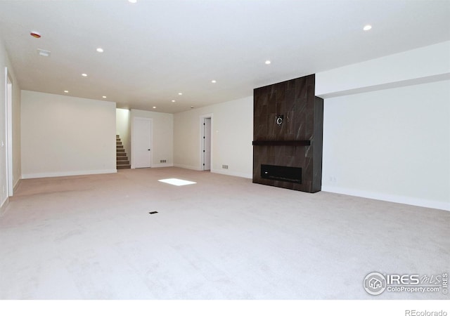 unfurnished living room with a fireplace and light colored carpet