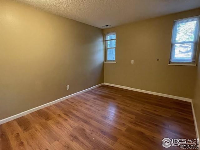 3345 Chisholm Trl Unit 105C, Boulder, CO 80301 - empty room featuring wood finished floors, baseboards, and a textured ceiling