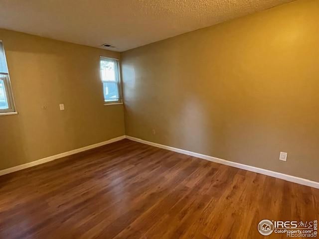 3345 Chisholm Trl Unit 105C, Boulder, CO 80301 - unfurnished room with baseboards, dark wood-style flooring, and a textured ceiling