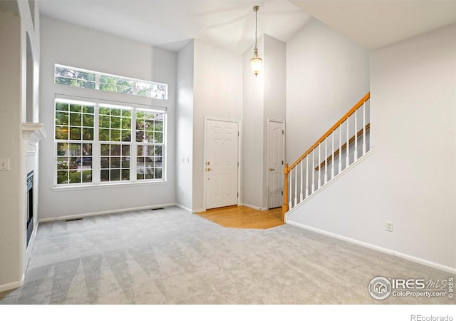 236 Remuda Ln, Lafayette, CO 80026 - entrance foyer with a fireplace, carpet floors, a towering ceiling, and baseboards
