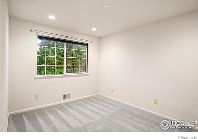 unfurnished room featuring light carpet