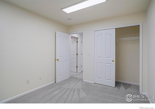 unfurnished bedroom with a closet and light carpet