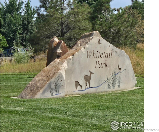 community / neighborhood sign with a yard