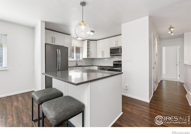 kitchen featuring a wealth of natural light, dark wood-type flooring, white cabinetry, and stainless steel appliances