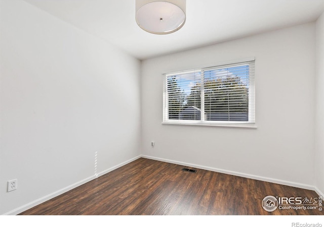 spare room with dark hardwood / wood-style flooring