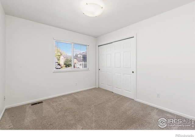 unfurnished bedroom featuring a closet and carpet flooring