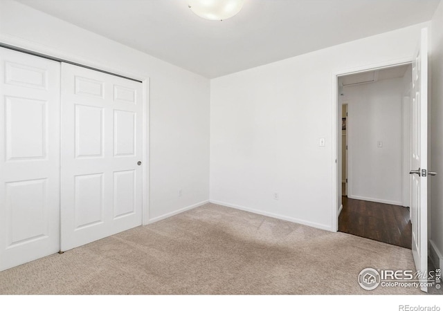 unfurnished bedroom with light carpet and a closet