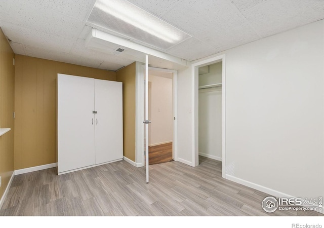 unfurnished bedroom with a closet and light hardwood / wood-style floors