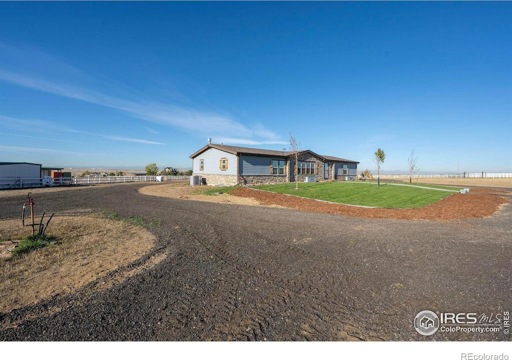 ranch-style house featuring a front yard and central AC