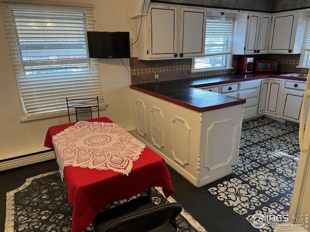 kitchen with a baseboard radiator, decorative backsplash, and white cabinetry