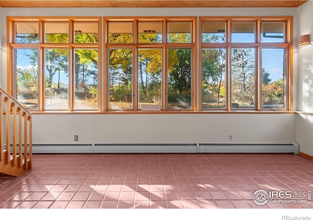 unfurnished sunroom featuring a baseboard heating unit