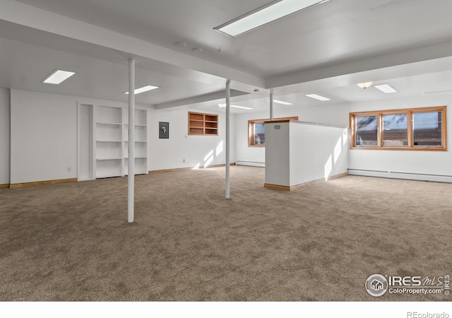 basement featuring a baseboard radiator, carpet floors, and electric panel