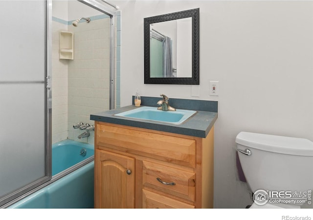 full bathroom featuring vanity, toilet, and combined bath / shower with glass door