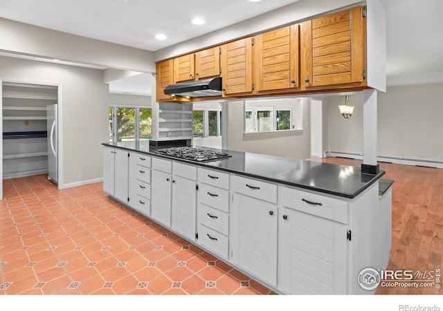 kitchen with white cabinetry, appliances with stainless steel finishes, and a baseboard heating unit