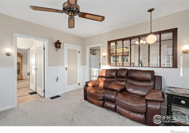 living room featuring light colored carpet and ceiling fan