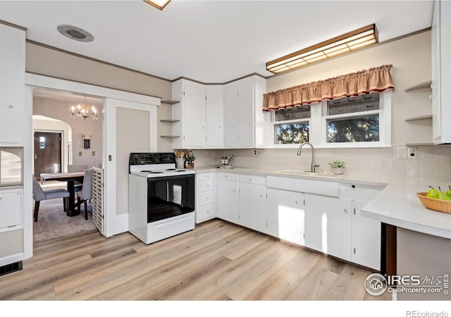 kitchen featuring electric range, backsplash, white cabinetry, light hardwood / wood-style flooring, and sink