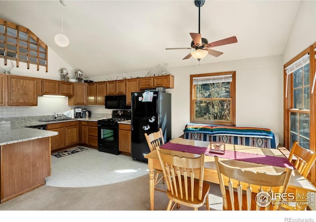 kitchen with ceiling fan, black appliances, vaulted ceiling, and backsplash