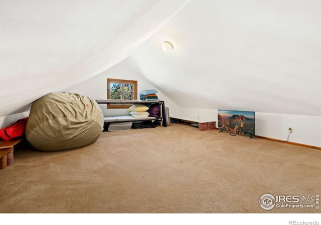 bonus room featuring vaulted ceiling and light colored carpet