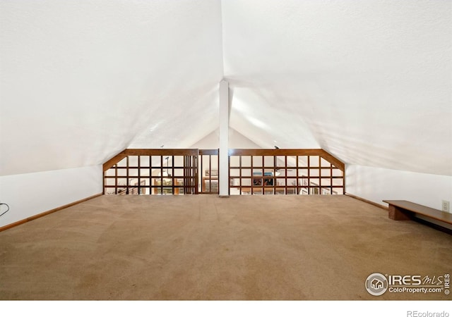 bonus room with vaulted ceiling and carpet floors