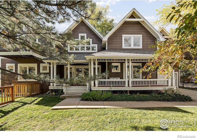 back of property with a lawn and a porch