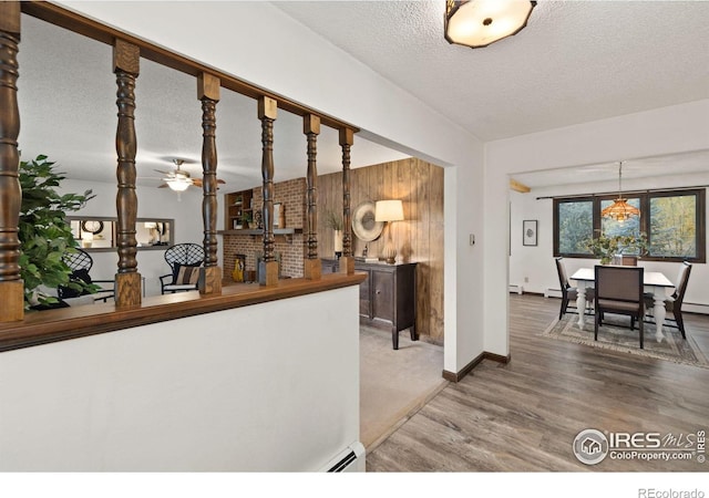 kitchen featuring hardwood / wood-style floors, a textured ceiling, and baseboard heating