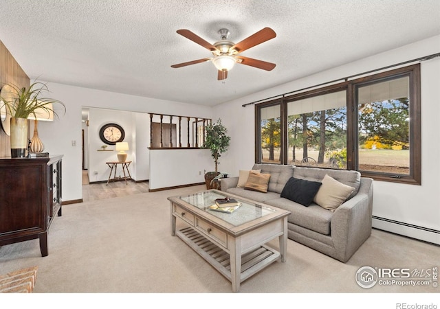 living room featuring ceiling fan, a baseboard radiator, light carpet, and a textured ceiling