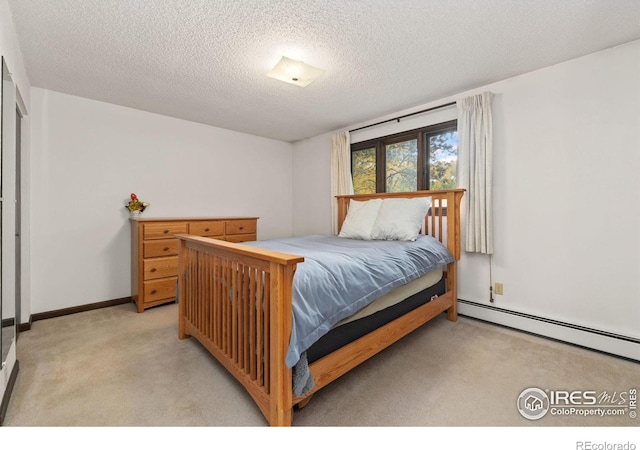 carpeted bedroom with a baseboard radiator and a textured ceiling