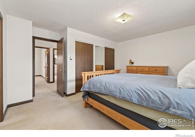 bedroom with light carpet and a textured ceiling