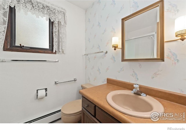 bathroom featuring vanity, toilet, and baseboard heating