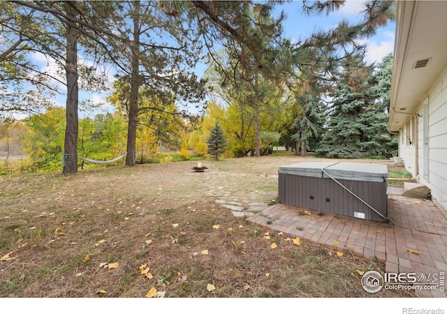 view of yard with a patio, visible vents, and a hot tub