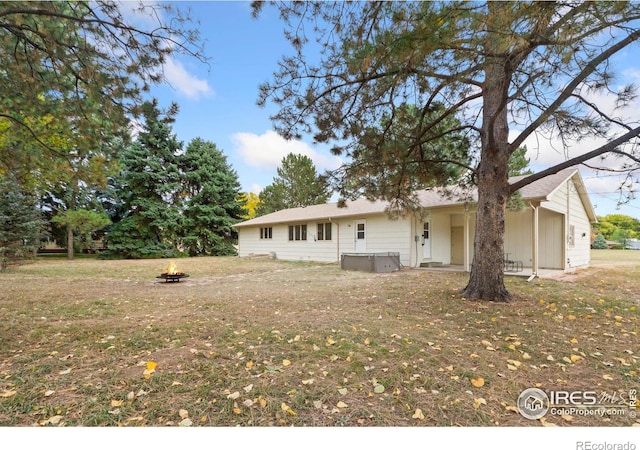 back of property featuring a hot tub and a fire pit