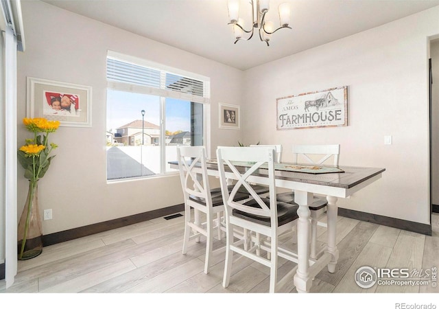 dining area featuring a notable chandelier and light hardwood / wood-style floors