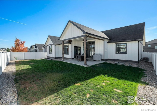 back of property with a yard and a patio