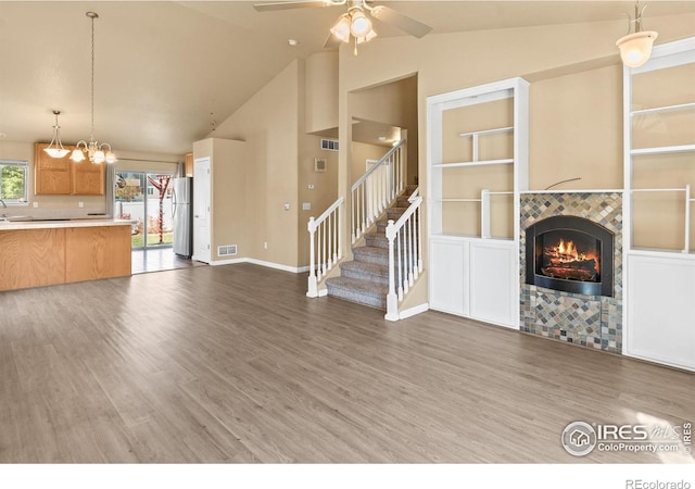 unfurnished living room featuring ceiling fan, a fireplace, high vaulted ceiling, and dark hardwood / wood-style floors