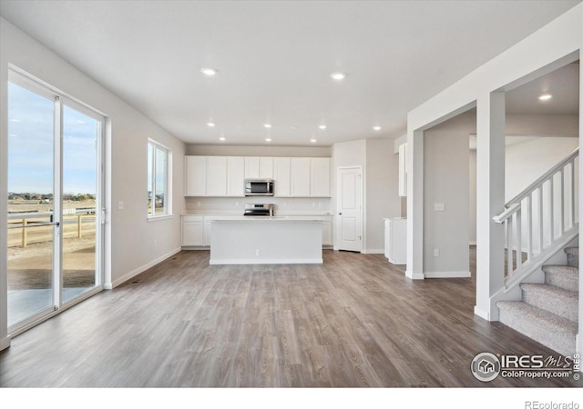 kitchen featuring a center island, light hardwood / wood-style flooring, white cabinets, and appliances with stainless steel finishes