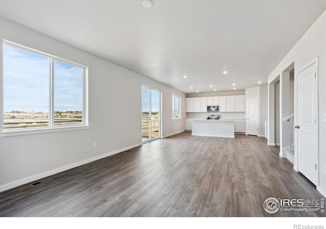 unfurnished living room with hardwood / wood-style floors and plenty of natural light