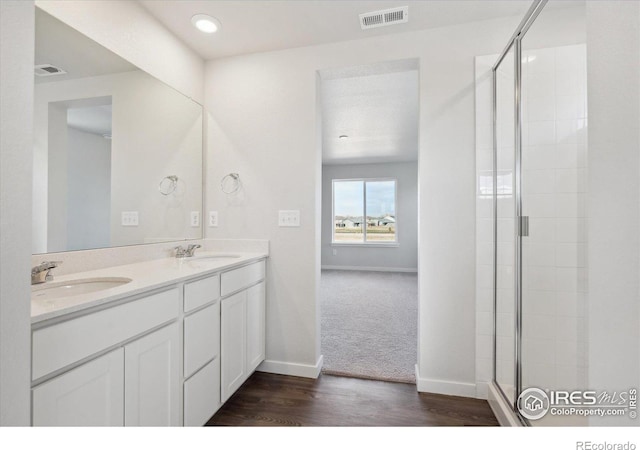 bathroom featuring hardwood / wood-style floors, vanity, and a shower with door