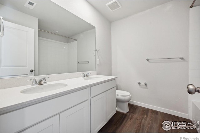 bathroom with hardwood / wood-style floors, vanity, and toilet